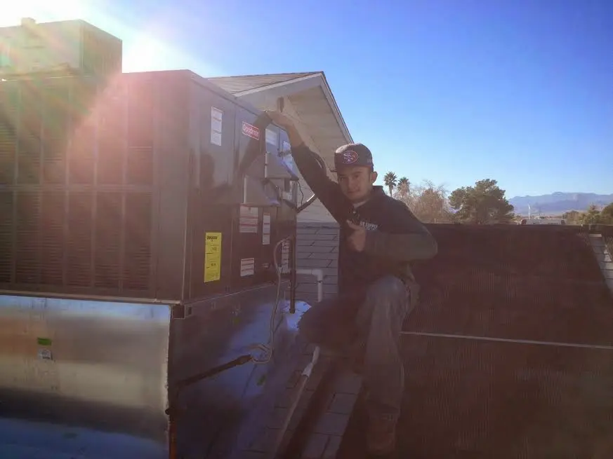 HVAC technician performing Heat Pump Repair on a rooftop unit in Grovetown